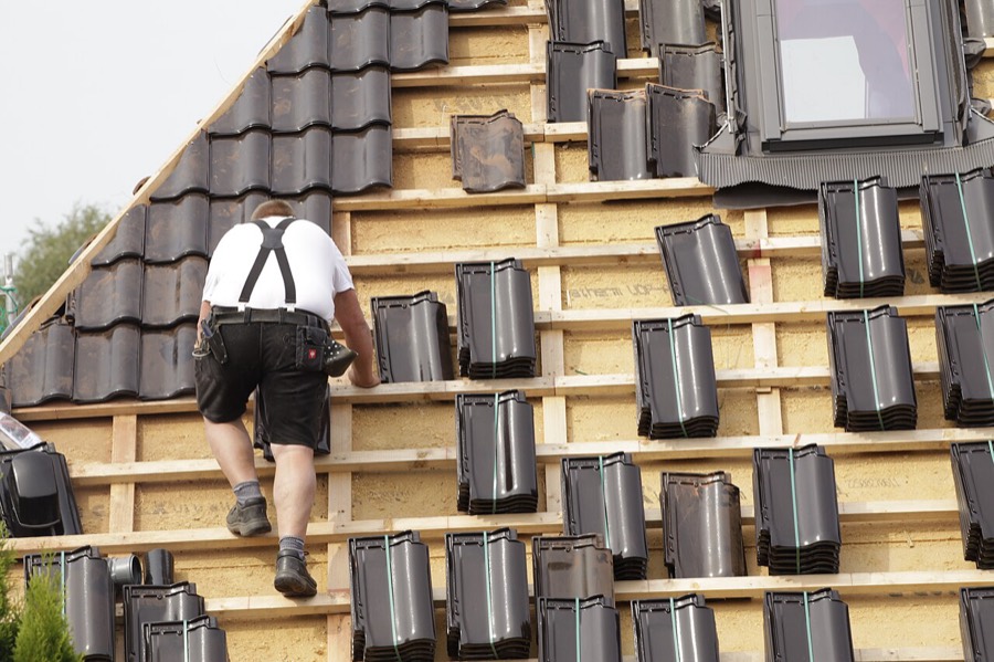 Roofer installing new roof tiles